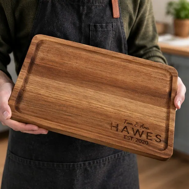 An acacia board engraved with a family surname in block capitals